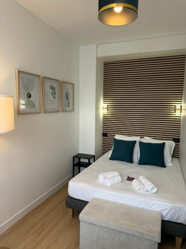 une chambre avec un grand lit blanc avec des oreillers bleus dans l'établissement G2 Joli 2 pièces calme RDC coté jardin centre Angouleme, à Angoulême