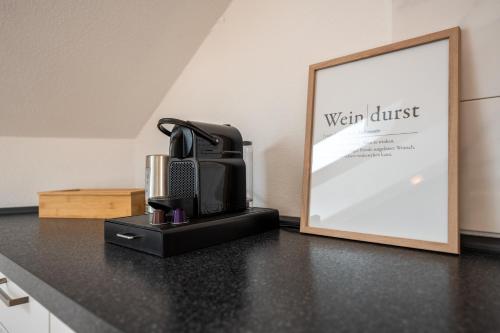 a microwave sitting on a counter next to a framed picture at SCHLOSSBERG RESIDENCES - Design City-Apartment Nähe SAP und Hockenheimring in Hockenheim