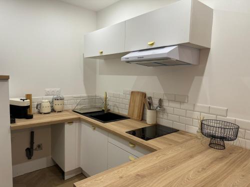a kitchen with white cabinets and a sink at Pause Nature Sauge in Ennevelin