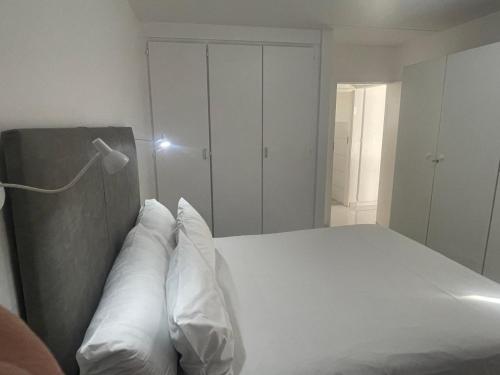 a bedroom with a white bed with two pillows at Palmar Hotel in Johannesburg