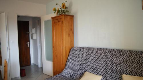 une chambre avec un lit et une armoire en bois dans l'établissement studio 150 m de la mer, à Six-Fours-les-Plages