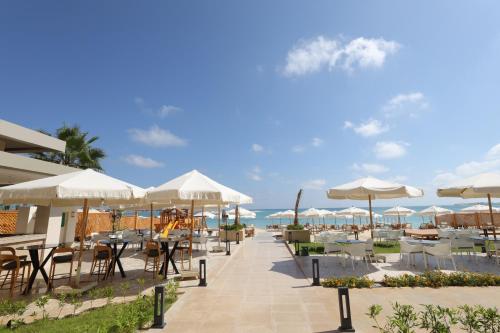 un restaurante con mesas y sombrillas en la playa en Hotel 59, en Marsa Matruh