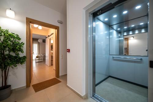 a glass shower door in a room with a hallway at HomEasy Apartments - Kalamata Central Getaways with Private Parking in Kalamata