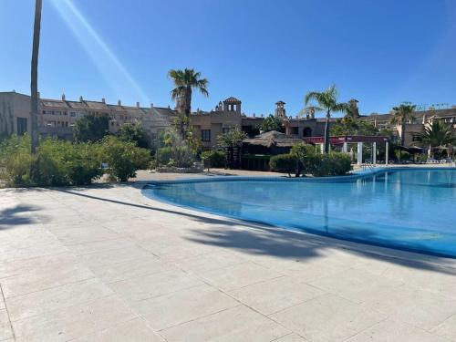 ein großer Swimmingpool mit Palmen und Gebäuden in der Unterkunft Magnifico Bungalow 2 plantas 110 m,con 3 piscinas in San Fernando