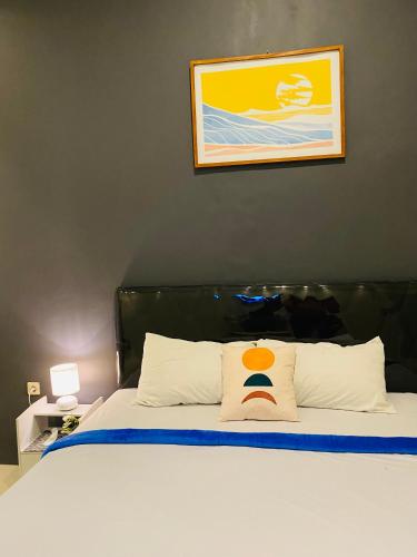 a bedroom with a bed with a picture on the wall at Robiu Bed & Breakfast in Banyuwangi