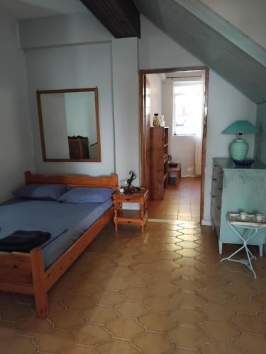 a bedroom with a bed and a mirror and a table at REPANTALIA Apartment in Zakynthos