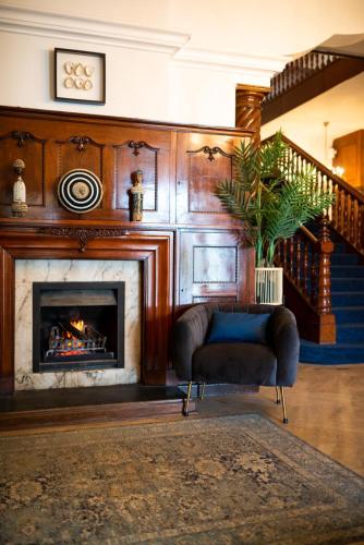 a living room with a fireplace and a chair at Palm House Boutique Hotel and Spa in Cape Town