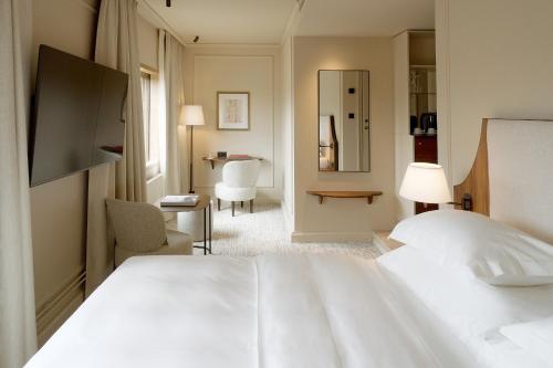 a hotel room with a white bed and a chair at Villa Dahlia in Stockholm