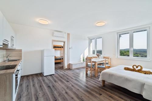 a bedroom with a bed and a kitchen and a table at Apartmány Jakub in Příseka