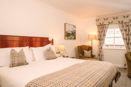 a bedroom with a bed and a chair and a window at Ansty Hall in Coventry