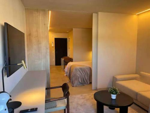 a room with a bed and a couch and a table at Resort y Piscina junto a la City in Murcia