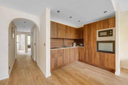 une cuisine avec des armoires en bois et un comptoir dans l'établissement Splendide appartement à Avenue Achille Peretti II, à Neuilly-sur-Seine