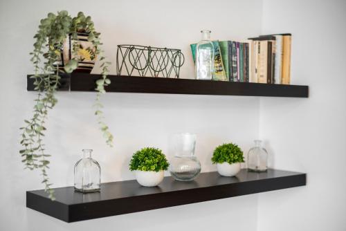 a black shelf with plants and vases on it at EnjoyGranada EMIR 3B y Parking in Granada