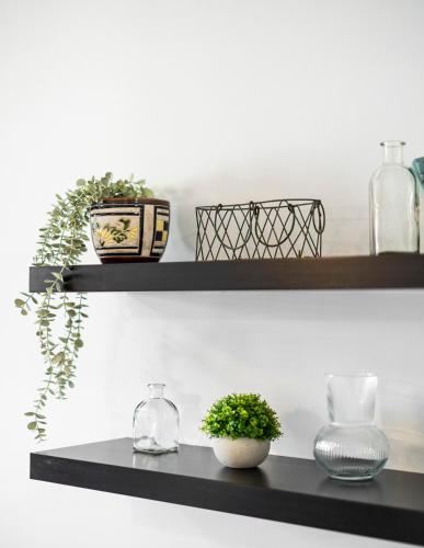 a black shelf with vases and plants on it at EnjoyGranada EMIR 3B y Parking in Granada