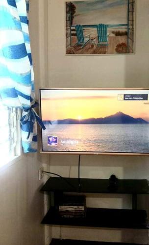 a flat screen tv sitting on top of a shelf at Seabreeze Guesthouse in Mocpoc Sur