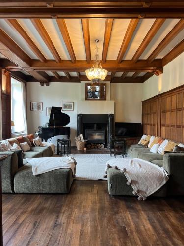 a living room with two couches and a piano at Manoir Nestor - Chairière in Vresse-sur-Semois