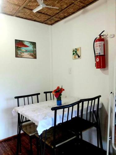 a white table with two chairs and a fire extinguisher at Seabreeze Guesthouse in Mocpoc Sur