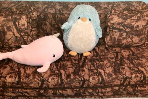 a stuffed penguin and a stuffed pig on a couch at Seabreeze Guesthouse in Mocpoc Sur