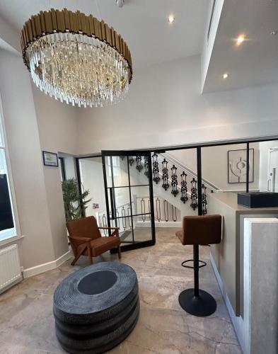 a living room with a chandelier and a large tire at Reem Hotel in London