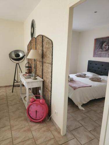 a bedroom with a bed and a clock on the floor at Appartement PALAZZI 2 in LʼÎle-Rousse