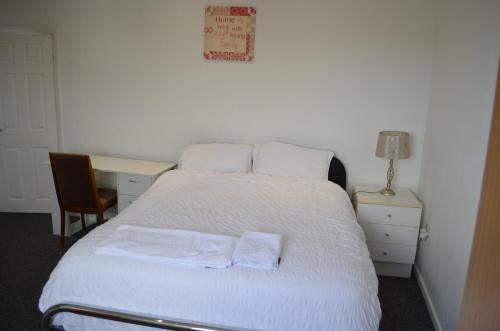 a bedroom with a bed with two towels on it at ACCANE in Sunderland