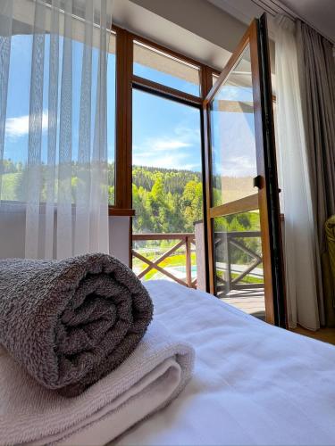 a bedroom with a bed and a large glass window at Hotel Skilandhouse in Bukovel