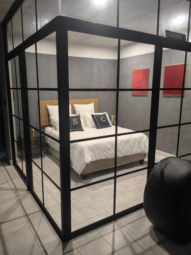Habitación con cama dentro de una pared de cristal. en Ultra-Modern Studio Apartment, en Table View