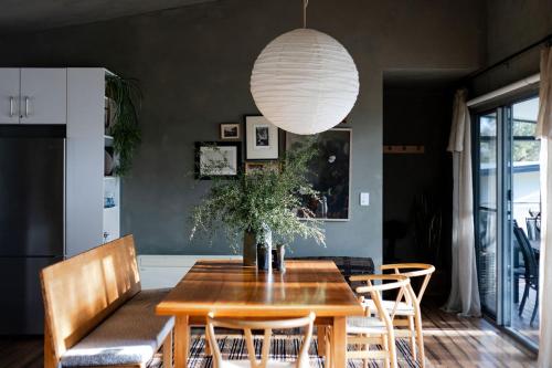 a dining room with a wooden table and chairs at Your Bruny Island Beach Getaway in Dennes Point