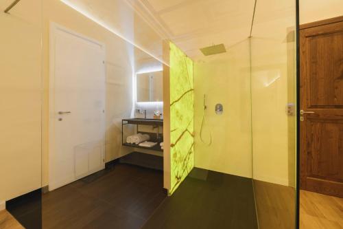 a bathroom with a shower and a glass door at Palazzo Patrizi Suites & Spa in Siena