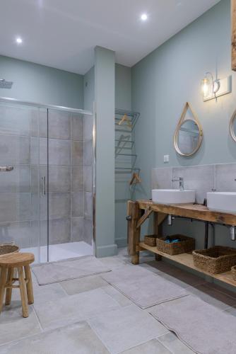 une salle de bain avec un lavabo et une douche dans l'établissement Gîte Saint Louis, à Espiens