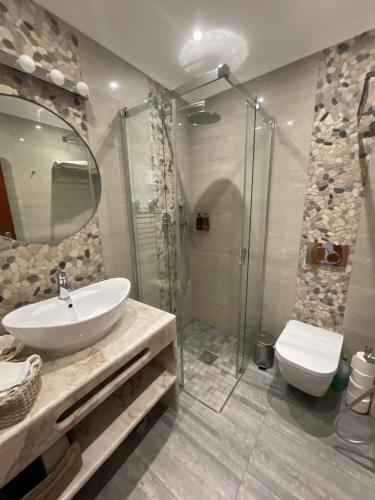 a bathroom with a sink and a shower and a toilet at The Birds Nest in Alvor