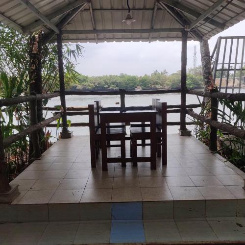 a table and chairs on a porch with a view of the water at Vista Al Rio in Māttūl