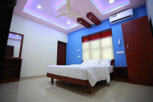a bedroom with a bed with a blue wall at Vista Al Rio in Māttūl
