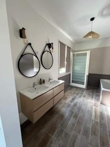 a bathroom with a sink and two mirrors on the wall at Nel Home in Mazan