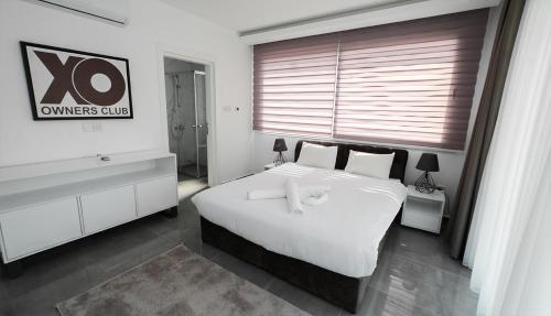 a bedroom with a large white bed and a window at xo courtyard long beach in Iskele
