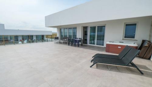 a large patio with chairs and tables on a building at xo courtyard long beach in Iskele