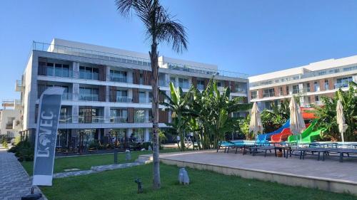 a building with tables and umbrellas in a park at xo courtyard long beach in Iskele