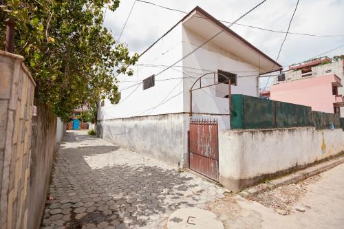 an alley with a white building and a fence at Apartment at KTM in Bālāju