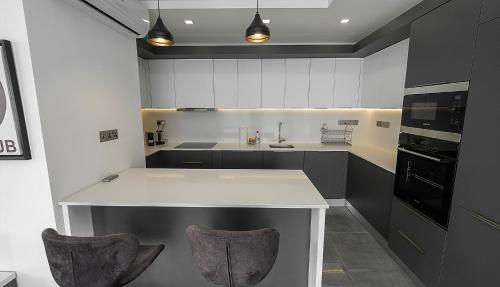 a kitchen with a white counter and two bar stools at xo courtyard long beach in Iskele