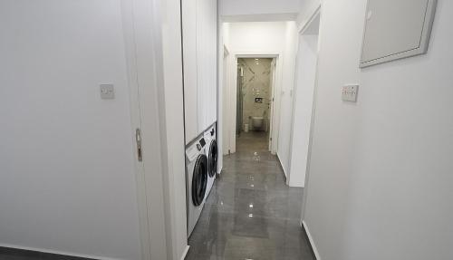 a hallway with a washing machine in a white room at xo courtyard long beach in Iskele