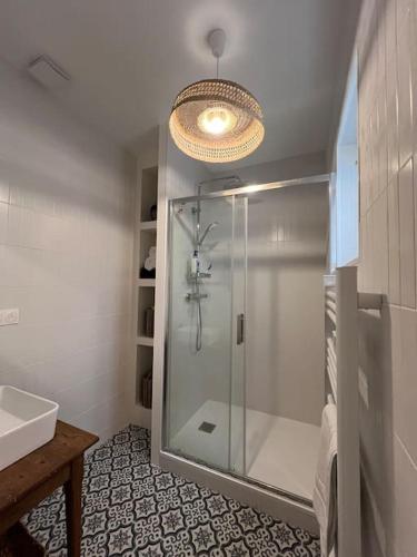 une salle de bain avec une douche avec une porte vitrée dans l'établissement La Maison de l'Estuaire, à Saint-Estèphe