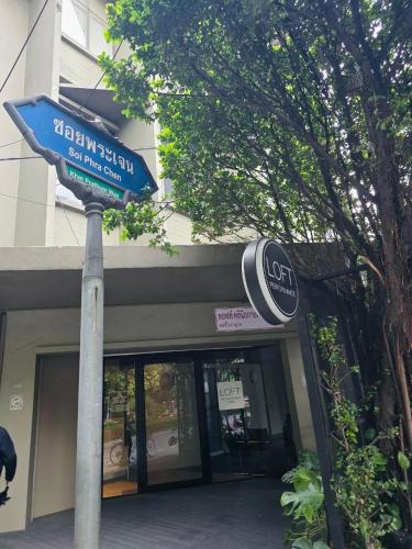 a blue street sign in front of a store at Twenty-one BKK House in Bang Kapi