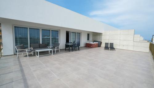 a large patio with chairs and tables on a building at xo courtyard long beach in Iskele