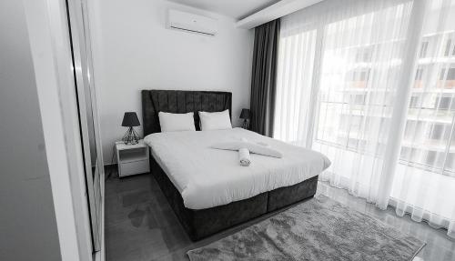 a bedroom with a bed with white sheets and a window at xo courtyard long beach in Iskele