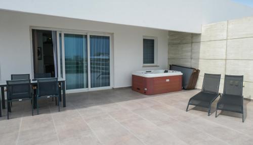a patio with a table and chairs and a tub at xo courtyard long beach in Iskele