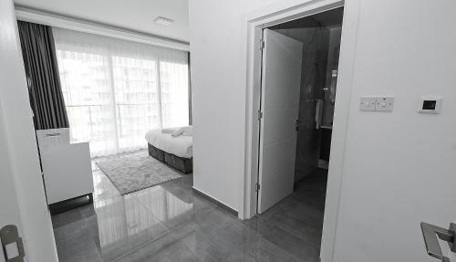 a white room with a bed and a door to a bedroom at xo courtyard long beach in Iskele