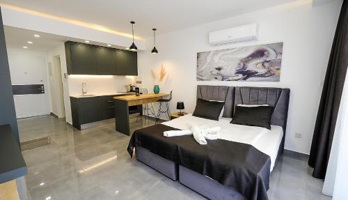a bedroom with a bed and a desk and a kitchen at xo courtyard long beach in Iskele