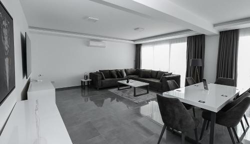 a living room with a couch and a table and chairs at xo courtyard long beach in Iskele