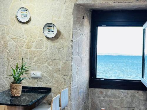 ein Zimmer mit einem Tisch und einem Fenster mit Blick auf das Meer in der Unterkunft Su Casita Marinera in Escarabote