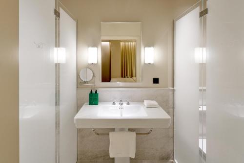 a white bathroom with a sink and a shower at Villa Dahlia in Stockholm